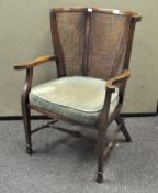 An early 20th century Oak and Bergere armchair by B Maggs & Co, Bristol,