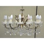 A twelve light gilt metal chandelier, with glass drip pans and glass droplets,