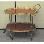 A vintage brass and veneer tea trolley, two tiered,