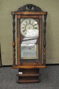 A late Victorian mahogany and inlaid wall clock, the dial with Roman numerals denoting hours,