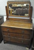 An Edwardian oak dressing table, with swing mirror above three long drawers,