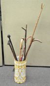 A ceramic stick stand containing various walking sticks,