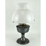 A vintage oil lamp with glass shade