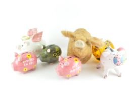 A group of five piggy banks; a mid century glass pig,