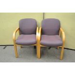 A pair of modern armchairs with an oak finish,