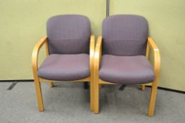 A pair of modern armchairs with an oak finish,