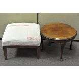 A 20th century mahogany coffee table and a footstool upholstered in cream and red cotton,