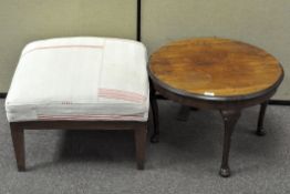 A 20th century mahogany coffee table and a footstool upholstered in cream and red cotton,
