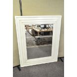 A large bevelled plate mirror with white painted stepped frame,