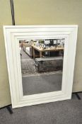 A large bevelled plate mirror with white painted stepped frame,