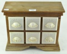 A vintage spice rack with six ceramic drawers,