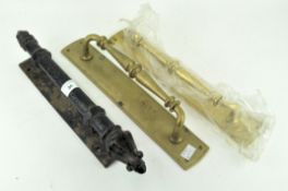 Three metal door pulls, comprising: two brass examples and a cast-iron example,