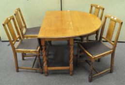 An oak drop-leaf table and four dining chairs, on barley twist legs,
