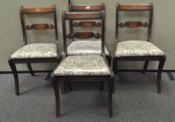 A set of four Victorian mahogany dining chairs with ribbon carved backs, each with drop-in seats,