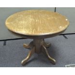 A wooden breakfast table, of circular form,