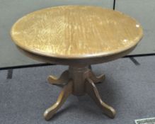 A wooden breakfast table, of circular form,