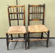 Two rush seated chairs with spindle backs and turned stretchers,