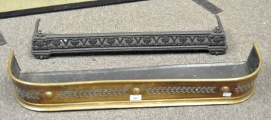 Two fire fenders, one being brass, both with pierced decoration,