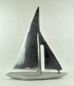 A modern chrome finished model of a stylised yacht,
