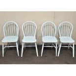 A set of four wheel back dining chairs, painted blue,