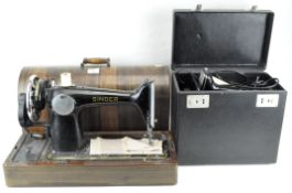 Two Singer sewing machines, including EH 210890, both cased, the largest 50.5 cm.