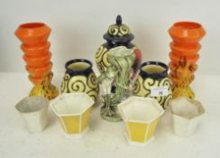 A collection of pottery vases, a frog candlestick,
