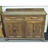 An Art Deco style oak sideboard, two drawers over two single door cupboards,