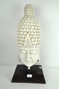 A large resin bust of Buddha, white in colour, mounted on wooden stand,