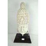 A large resin bust of Buddha, white in colour, mounted on wooden stand,