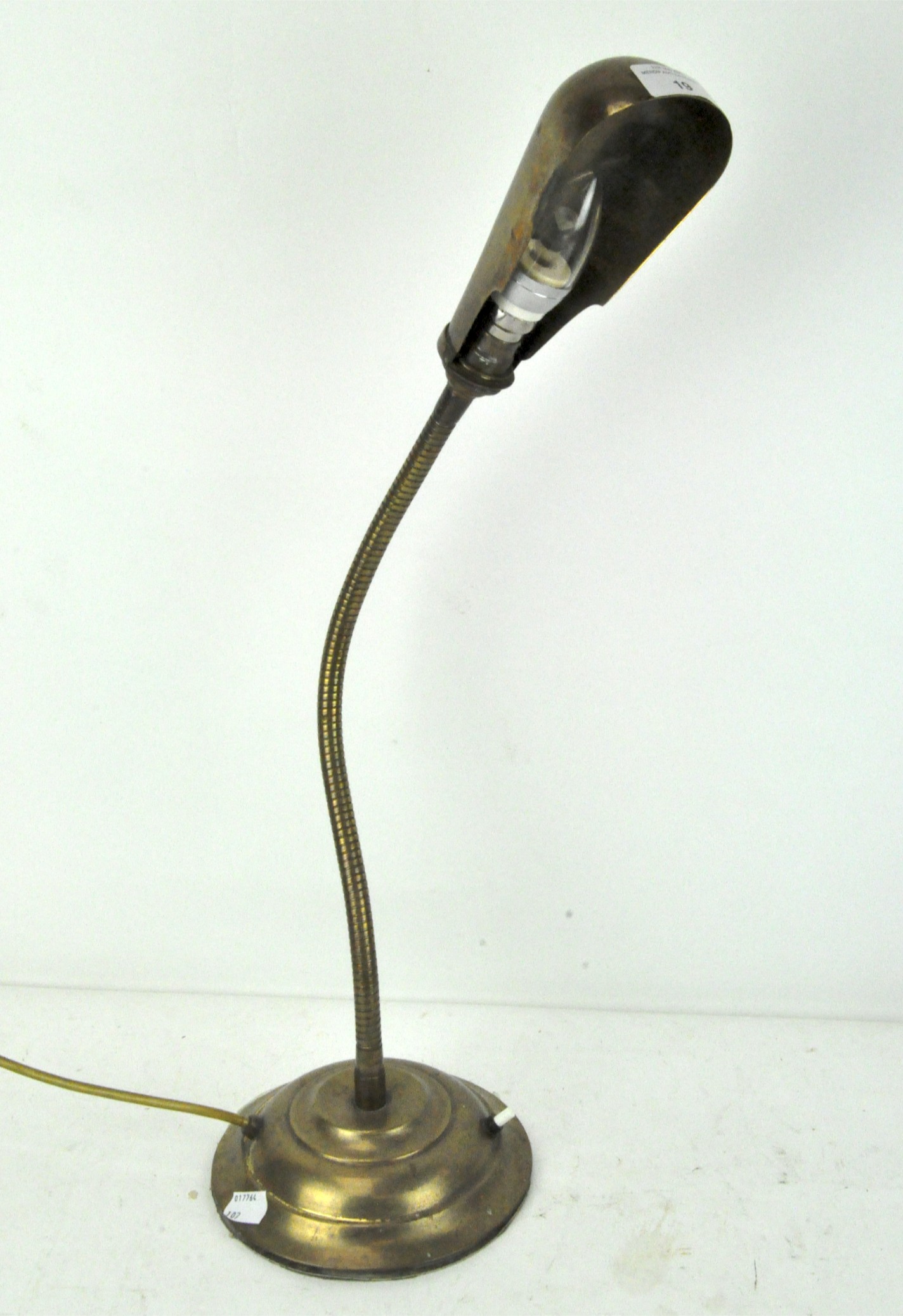A vintage brass desk lamp of articulated form,