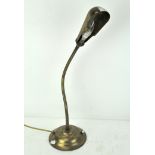 A vintage brass desk lamp of articulated form,