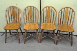 A set of four oak Windsor style kitchen chairs with X stretchers,