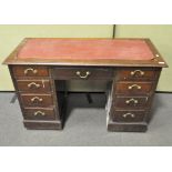 A mahogany kneehole desk, inset with leather top, with four drawers to either side, 20th century,