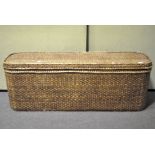 A large wicker storage unit/seat of oblong form,