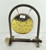 A 20th century brass gong on stand, adorned with cross like decoration,