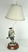 A Continental porcelain figure of a Town Crier, mounted as a table lamp,