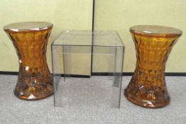 A pair of Kartell Stone stools, orange in colour, designed by Marcel Wanders,
