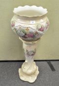 A 20th century ceramic jardiniere on stand, decorated with floral sprays amongst gilt leaves,