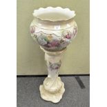 A 20th century ceramic jardiniere on stand, decorated with floral sprays amongst gilt leaves,