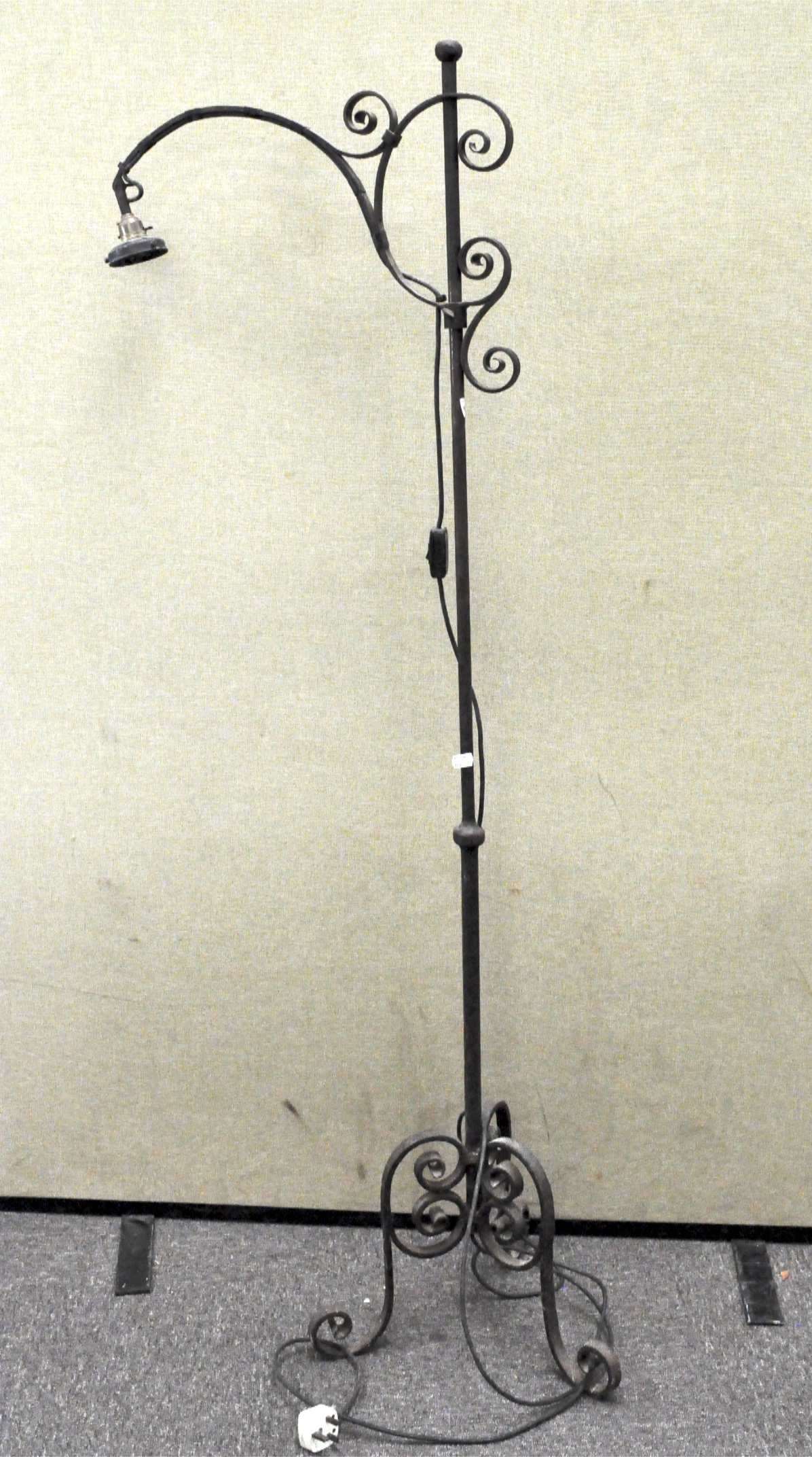 A cast iron standard lamp, raised on flowing legs,