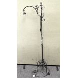 A cast iron standard lamp, raised on flowing legs,