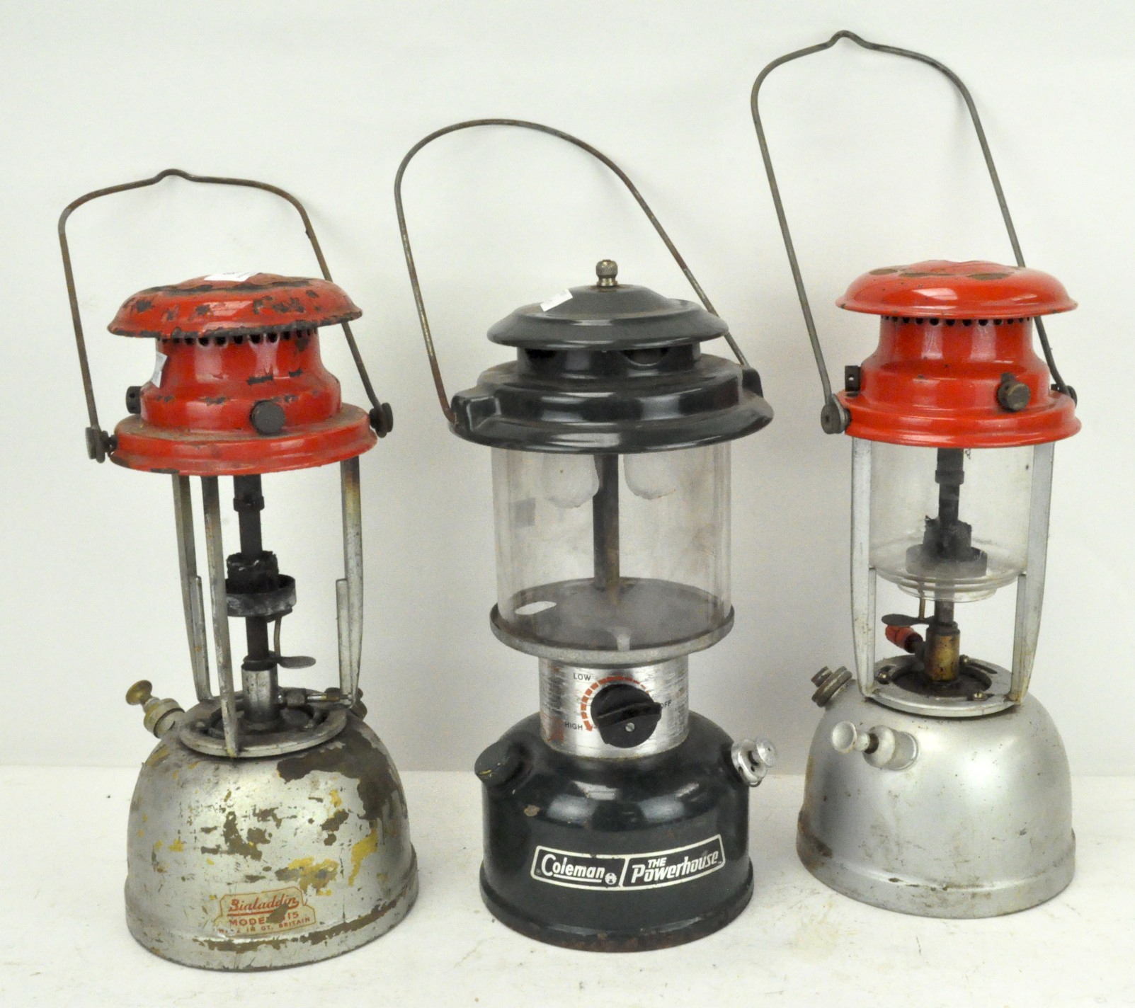 A group of three hanging lanterns, each with enamel tops,