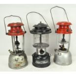 A group of three hanging lanterns, each with enamel tops,