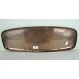 An Arts and Crafts hammered copper tray of oblong form, by Hugh Wallace,