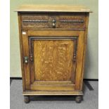 An oak cupboard with a fitted single drawer above a door with shelving,