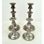 A pair of silver plated candlesticks and another pair,