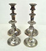 A pair of silver plated candlesticks and another pair,
