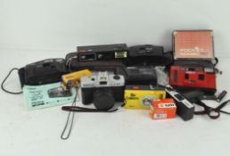 A collection of compact cameras, including a Canon sure shot AF-7,