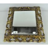 A small gilt wall mirror, with pierced and foliate frame and bevelled edge,