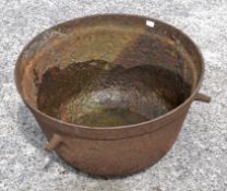 A metal cauldron with three handles,